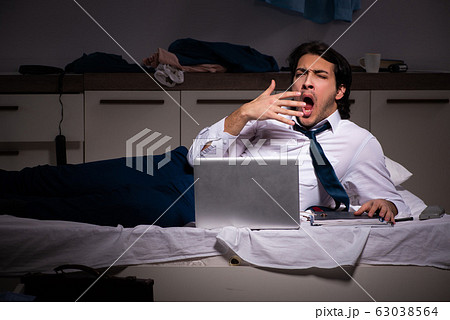 Young employee working at home after night shift 63038564