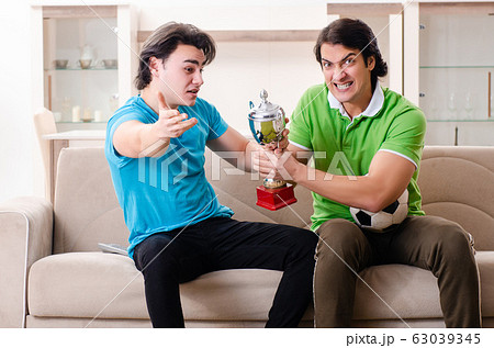 Friends watching football at home Friends watching football at home 63039345