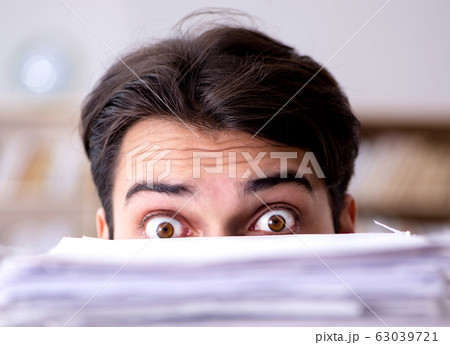 Businessman struggling to meet challenging deadlines Businessman struggling to meet challenging deadlines 63039721