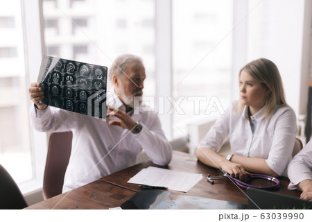 Head doctor of the hospital department explains to his colleagues the result Head doctor of the hospital department explains to his colleagues the result 63039990