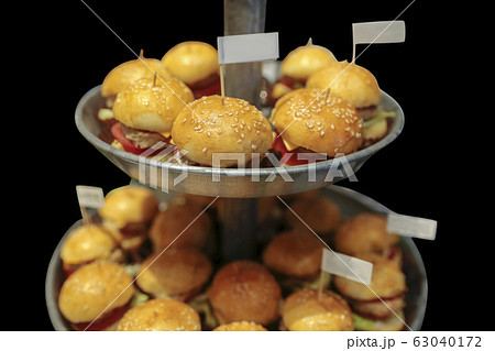 Mini beef burgers party food, in black background. 63040172