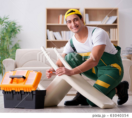 Furniture repairman repairing armchair at home 63040354