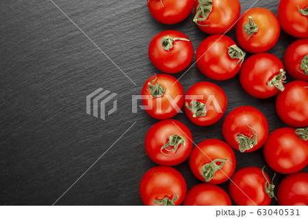 Fresh tomatoes on a black cutting board. Fresh tomatoes on a black cutting board. 63040531