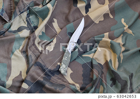Military knife on army camouflage clothes close 63042653