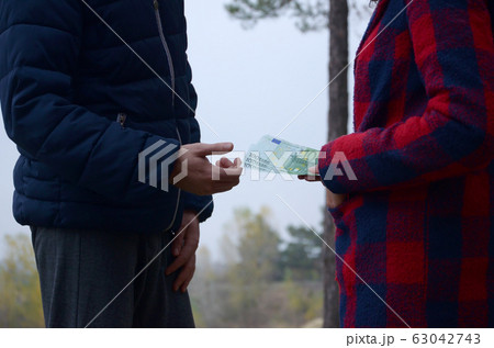 Girl transfers euro bills to the hands of a young Girl transfers euro bills to the hands of a young 63042743