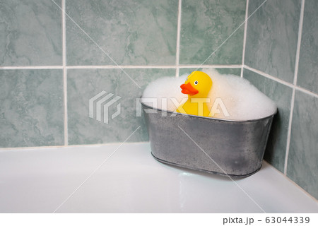 Yellow rubber duck in the bathtub with a soap and foam Yellow rubber duck in the bathtub with a soap and foam 63044339