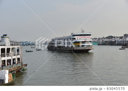 バングラデシュ　ダッカのショドル・ガット　ブリゴンガ川を進むレトロな中型フェリーと周辺の街並み 63045570