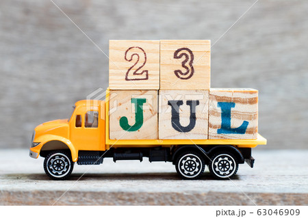 Truck hold letter block in word 23jul on wood background  63046909