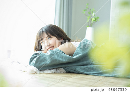 床に寝そべる若い女性 63047539
