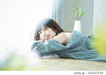 床に寝そべる若い女性 63047540