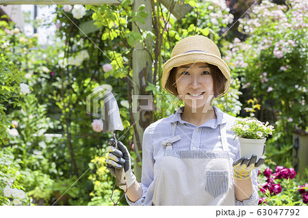 ガーデニングイメージ 花の苗を持つ女性 カメラ目線の写真素材