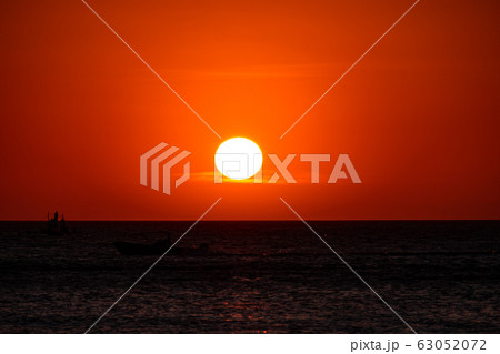 Boracay, Philippines - Jan 21, 2020: Sunset on the background of bottles standing on the bar. The sun passes through the bright glass of the bottles. Background image for the screensaver. 63052072