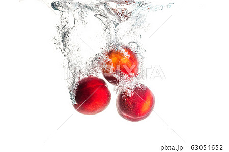 Nectarine fruits splashing into water and sinking Nectarine fruits splashing into water and sinking 63054652