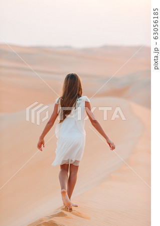 Girl among dunes in desert in United Arab Emirates 63056185
