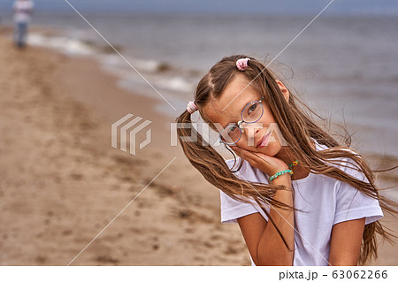 Portrait of a teenage girl in glasses and a white 63062266