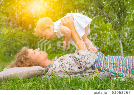Holidays: Happy Mothers Day. Mother with child outdoor. Positive emotions of mother and toddler Holidays: Happy Mothers Day. Mother with child outdoor. Positive emotions of mother and toddler 63062267