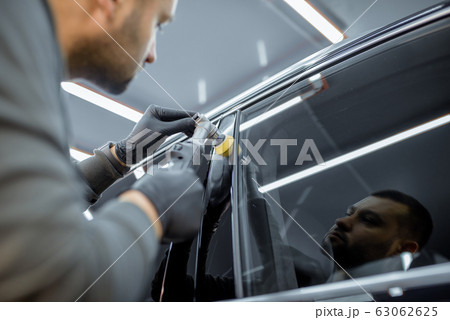 Man polishing vehicle body from scratches 63062625