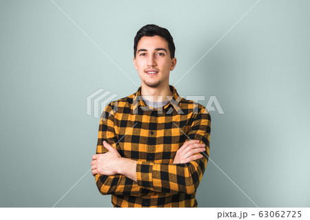 confidence and reliability. closeup crossed arms of a man on grey background with copy space 63062725