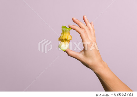 close up tender female hand gently holding an apple core over pastel pink background. healthy food concept close up tender female hand gently holding an apple core over pastel pink background. healthy food concept 63062733