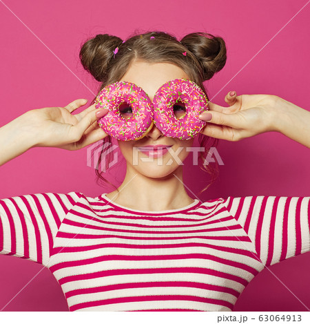 Attractive young woman showing two donuts  63064913