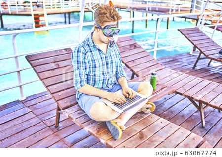 A man is working on vacation. 63067774