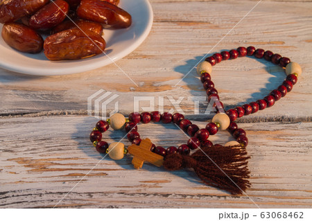 Rosary and plate of fruit dates. 63068462