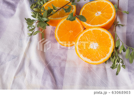 Juicy orange with green leaves on white fabric. Juicy orange with green leaves on white fabric. 63068903