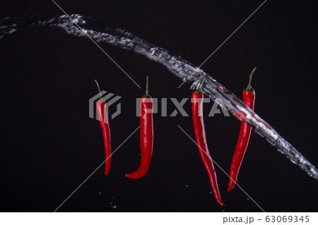 Four peppers with stream of water. 63069345
