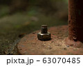 bolt screw nut rusty on concrete floor. 63070485