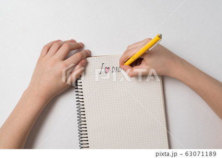 Children's hands are doing the writing in notebook 63071189