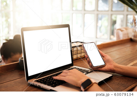 Mockup image of a businesswoman using laptop with blank white desktop screen with coffee cup on wooden table in cafe Mockup image of a businesswoman using laptop with blank white desktop screen with coffee cup on wooden table in cafe 63079134