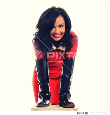 Young slim woman in red dress and brown boots 63080690