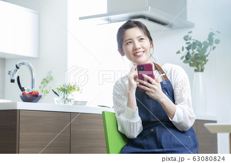 若い女性・リビングダイニング・スマホ・検索 63080824