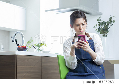 若い女性・リビングダイニング・スマホ・検索 63080831