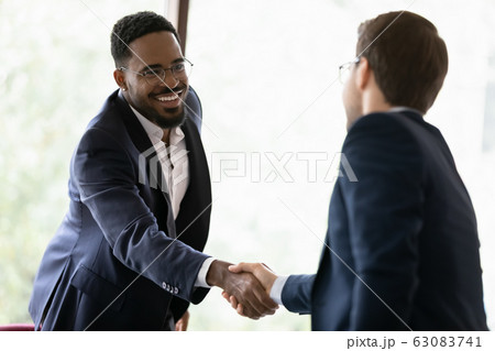 Diverse male colleagues handshake get acquainted at meeting Diverse male colleagues handshake get acquainted at meeting 63083741