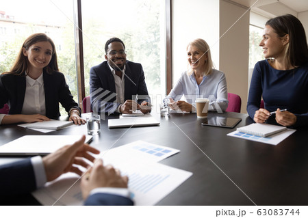 Smiling diverse colleagues laugh discussing ideas at meeting 63083744