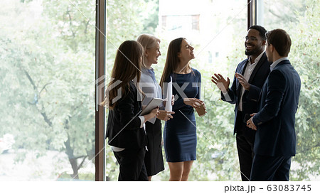 Smiling diverse colleagues have fun talking in office Smiling diverse colleagues have fun talking in office 63083745