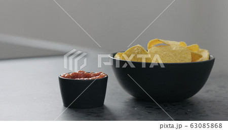 serve corn chips with salsa on concrete surface 63085868