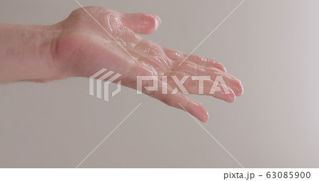 pour shower gel on man hand closeup 63085900