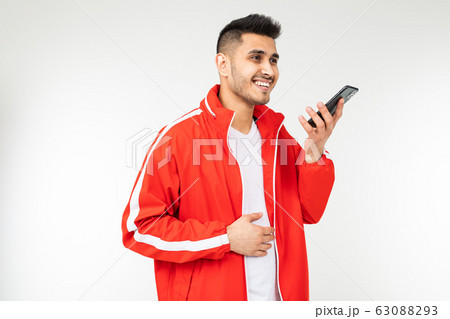man in sportswear in red talks on the phone on a white background man in sportswear in red talks on the phone on a white background 63088293
