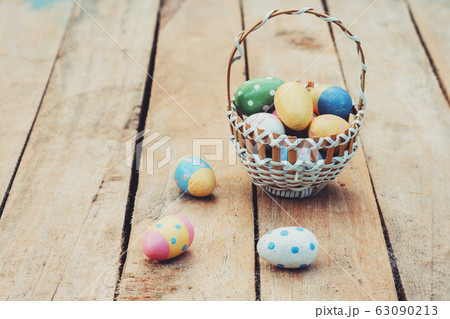 colourful easter egg and basket on wood background 63090213