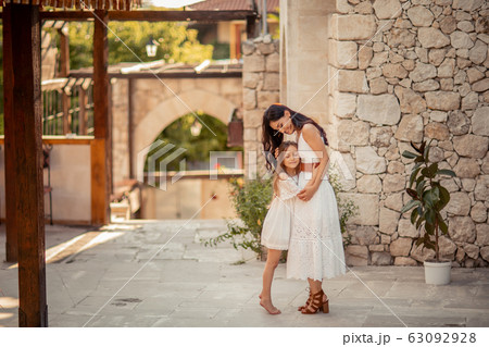 Young beautiful mother of eastern appearance walks with her daughter on the ancient streets of the Mediterranean city 63092928