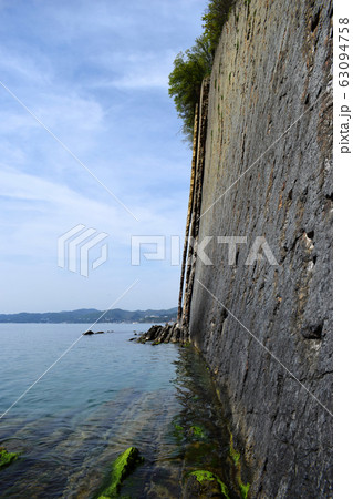 Side view of the Kiselev rock on The black sea coast. Natural stone wall created by nature . Flat rock. Beautiful view of the coast. Side view of the Kiselev rock on The black sea coast. Natural stone wall created by nature . Flat rock. Beautiful view of the coast. 63094758