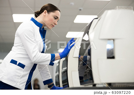 Female scientist using advia immunoassay system in laboratory 63097220