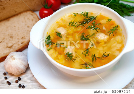 Chicken soup with meatballs and pasta on the table 63097514