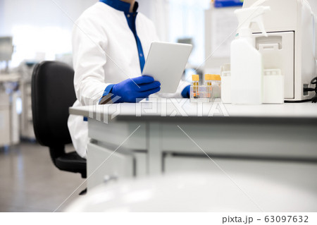 Research scientist in sterile gloves holding digital tablet Research scientist in sterile gloves holding digital tablet 63097632