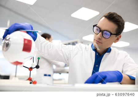 Male research scientist working with anatomy eyeball model Male research scientist working with anatomy eyeball model 63097640