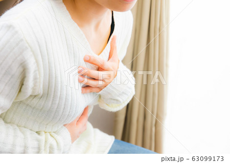 胸を抑える女性　胸痛　息苦しい　様々な疾病 63099173