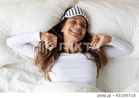 Happy millennial girl stretching awaken in bedroom 63100718