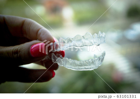 Invisible dental retainer held by womans hand 63101331